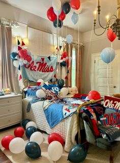 a bedroom decorated in red, white and blue balloons