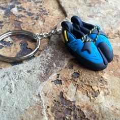 a blue shoe keychain sitting on top of a rock