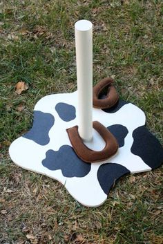 a wooden toy with a cow print design on it and a white pole sticking out of the ground