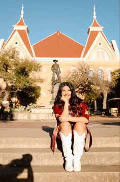 a woman sitting on steps in front of a building