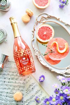 grapefruit, oranges and macaroni are on the table next to wine bottles