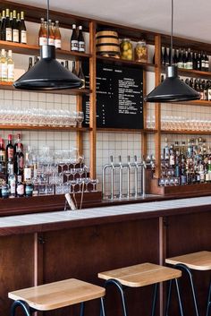 the bar is stocked with many different types of liquors and drinks, along with several stools