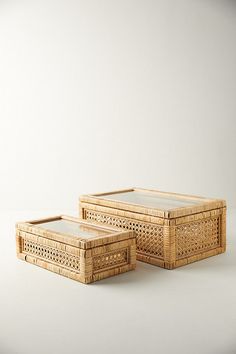 two wicker boxes sitting next to each other on top of a white countertop