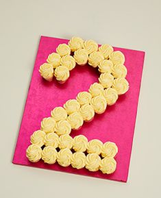 a pink and yellow card with the number two made out of cupcakes on it