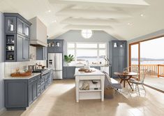 a large kitchen with blue cabinets and white counter tops, along with an island in the middle