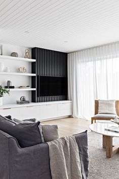 a living room filled with furniture and a flat screen tv on top of a wall