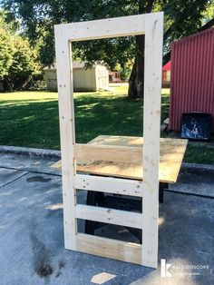 a large mirror sitting on top of a wooden table in the middle of a yard