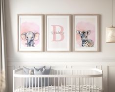 a baby's room with three framed pictures on the wall and a crib