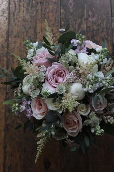 a bouquet of flowers sitting on top of a wooden table