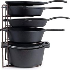 a stack of black pots and pans on a metal rack