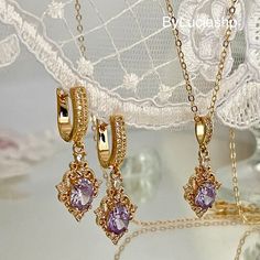 Immerse yourself in the charm of the past with our dazzling art deco jewelry set. This set includes an elegant necklace and a pair of earrings reminiscent of art deco and art nouveau styles, both adorned with exquisite lilac amethyst crystals and zircons that spectacularly capture the light. The necklace, crafted in gold, adds a touch of luxury to your look, while the art deco huggie earrings offer a unique and comfortable design. Perfect for adding a touch of vintage glamor to any outfit, this Art Deco Jewelry With Matching Earrings, Elegant Purple Earrings For Her, Elegant Gold Amethyst Jewelry, Elegant Purple Earrings As A Gift For Her, Elegant Gold-plated Jewelry Sets With Pendant, Dainty Purple Jewelry With Matching Earrings, Elegant Gold Plated Jewelry Sets With Pendant, Art Deco Cubic Zirconia Drop Earrings, Elegant Amethyst Pendant Jewelry