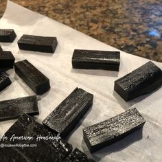 several pieces of black soap sitting on top of a paper towel next to a marble counter