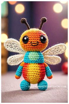 a small crocheted bee sitting on top of a table next to some lights