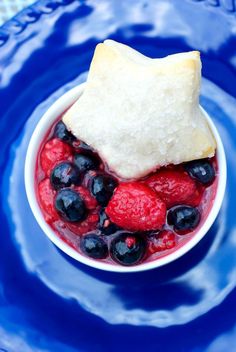 a bowl filled with fruit and bread on top of a blue plate