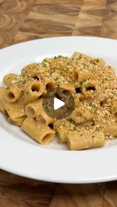 a white plate topped with pasta covered in sauce and parmesan sprinkles