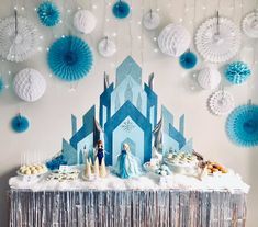 a table topped with cake and cupcakes covered in blue frosted icing