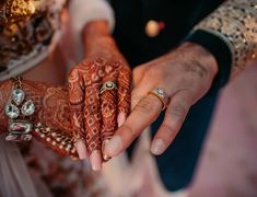 the bride and groom are holding hands with their wedding rings on each hand, which is decorated with jewels