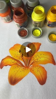 an orange flower painted with acrylic paint and watercolors on a white table cloth