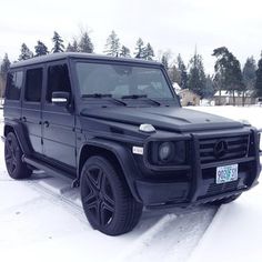 a black and white photo of a mercedes g - class in the snow with pink lettering