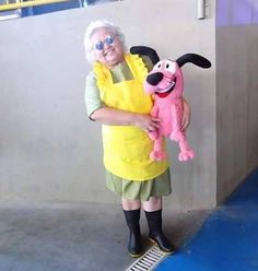 an old woman holding a stuffed animal dog in her arms while standing next to a ramp