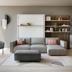 a living room filled with lots of furniture next to a wall mounted bookshelf