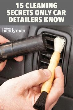 a person is cleaning the interior of a car with a brush and duster in their hand