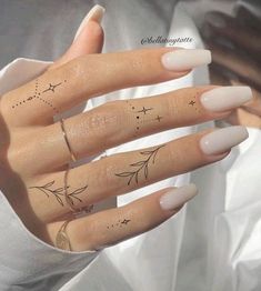 a woman's hand with four finger tattoos on her fingers and two stars in the middle