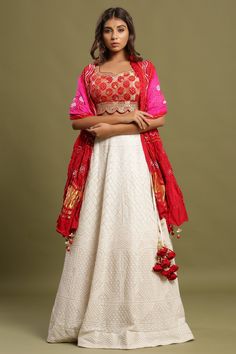 White self-embroidered Zari lehenga set featuring bandhej dual print dupatta and zari & gota patti embroidered red blouse. The lehenga also has a long tassel attached to tie the knot. Pair it with beautiful jewelry to enhance your look. Shop online from Pure Elegance. Disclaimer: The actual product may vary slightly from the image. These are custom orders, hence expect slight variation in color, placement of the motif, or buta. ESTIMATED DELIVERYBecause this is a custom order, it would take about 4 weeks from the date of purchase. RETURN POLICYThis product is a custom order and cannot be returned or exchanged. White Silk Lehenga, Zari Lehenga, Bandhej Print, Fashion Journals, Pure Elegance, Red Blouse, Tie The Knot, Traditional Fabric, Silk Lehenga