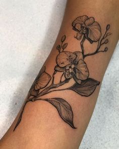 a black and white flower tattoo on the arm