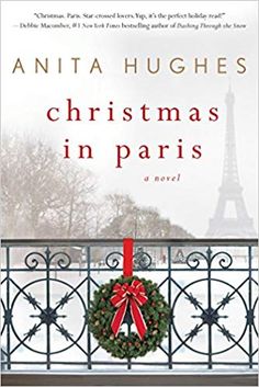 the cover of christmas in paris, with a wreath and bow hanging on a fence