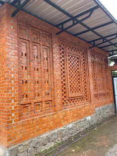 a red brick building with a metal roof and windows on the side of it that is made out of bricks