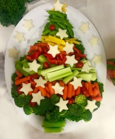 broccoli, carrots, and celery arranged in the shape of a christmas tree