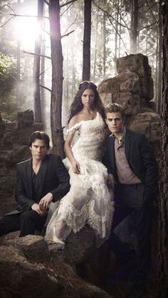 two men and a woman posing in the woods