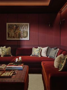 a living room filled with red couches and pillows