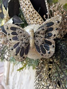 a christmas ornament with a black and gold butterfly on it's back