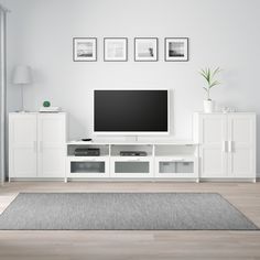 a flat screen tv sitting on top of a white entertainment center in a living room