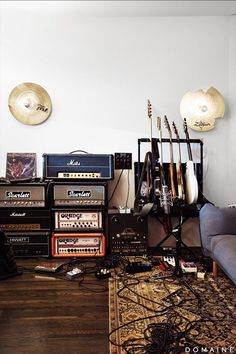 an assortment of musical instruments sitting on top of a wooden floor next to a couch