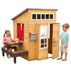 two children are playing in a wooden play house with a picnic table and chair set