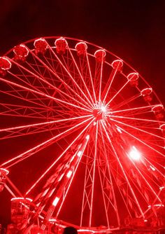 a red ferris wheel lit up at night