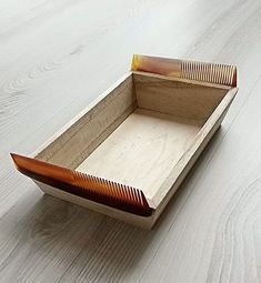 an empty wooden box sitting on top of a white floor