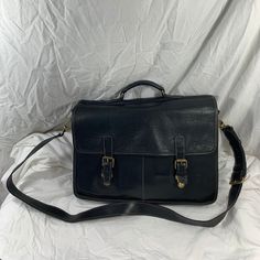 "Measurements are 17\" wide, 11\"5 high, 4\"7 deep with a 56 \"shoulder strap with a 24\" drop. On the interior there are two main compartments, unlined interior, two front pockets under flap with buckle like closures. The leather is nice and strong with light stitching, top handle, aged gold tone hardware, detachable shoulder strap and brief can be used crossbody.  This bag is great for work, school and travel and is spacious. 100% Roots made in Canada and is in very good condition for its age. School Bag Leather Black, Classic Flap Shoulder Bag For School, Vintage Rectangular Laptop Bag For Formal Use, Classic School Satchel With Leather Backing, Leather Flap Briefcase For Formal Use, Black Rectangular Saddle Bag For Formal Occasions, Vintage Briefcase For Business Trips, Classic Rectangular Saddle Bag For School, Classic Saddle Bag For School