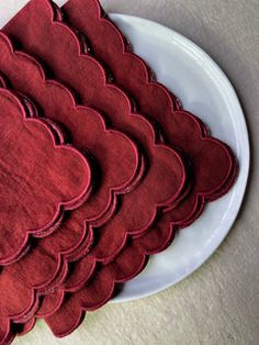 a white plate topped with lots of red heart shaped napkins on top of a table