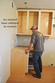 a man is standing in the corner of a room with some cupboards on it