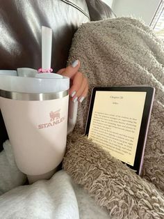 a woman sitting on a couch next to a book and coffee cup with the word start written in it