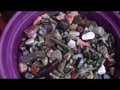 a purple bowl filled with lots of rocks