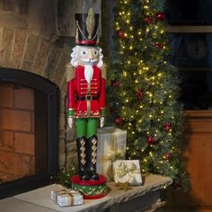 a wooden nutcracker sitting on top of a mantle next to a christmas tree