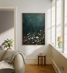 a painting hanging on the wall above a couch in a room with wooden flooring