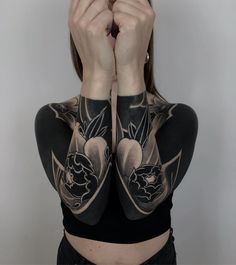 a woman with tattoos on her arms covering her eyes and hands behind her head,