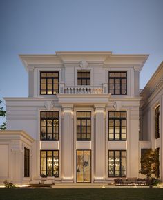 a large white building with lots of windows on the front and side of it at night