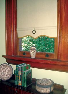 a wooden shelf with books and vases on it